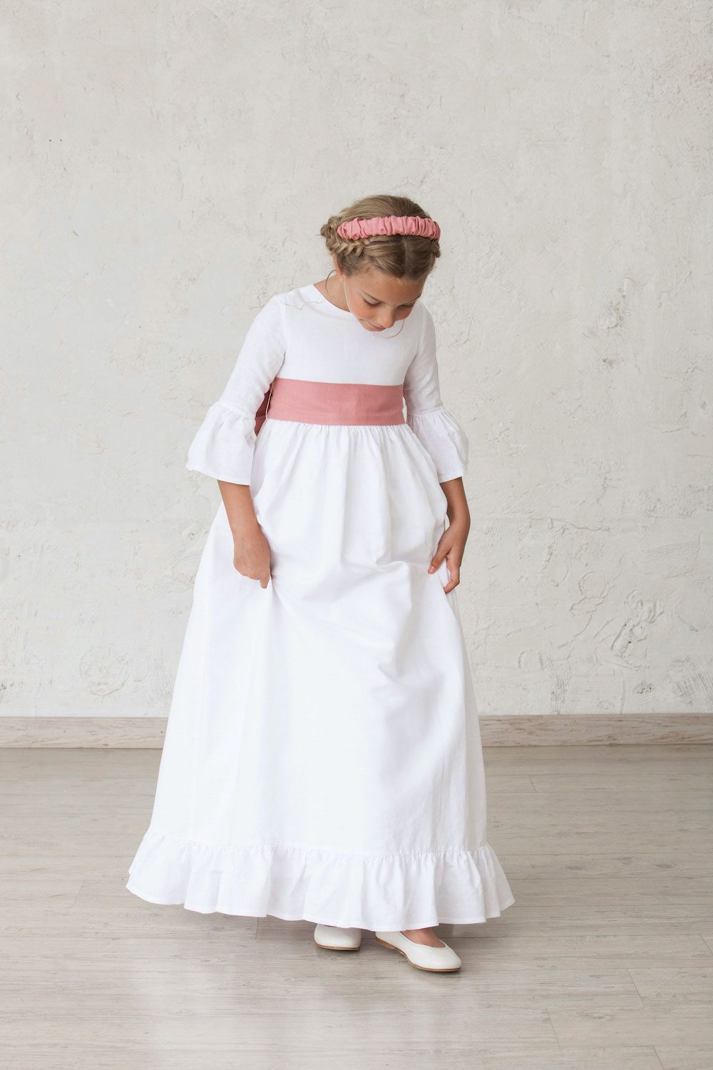 vestido blanco de comunión de niña con volantes en las mangas y el bajo de la falda