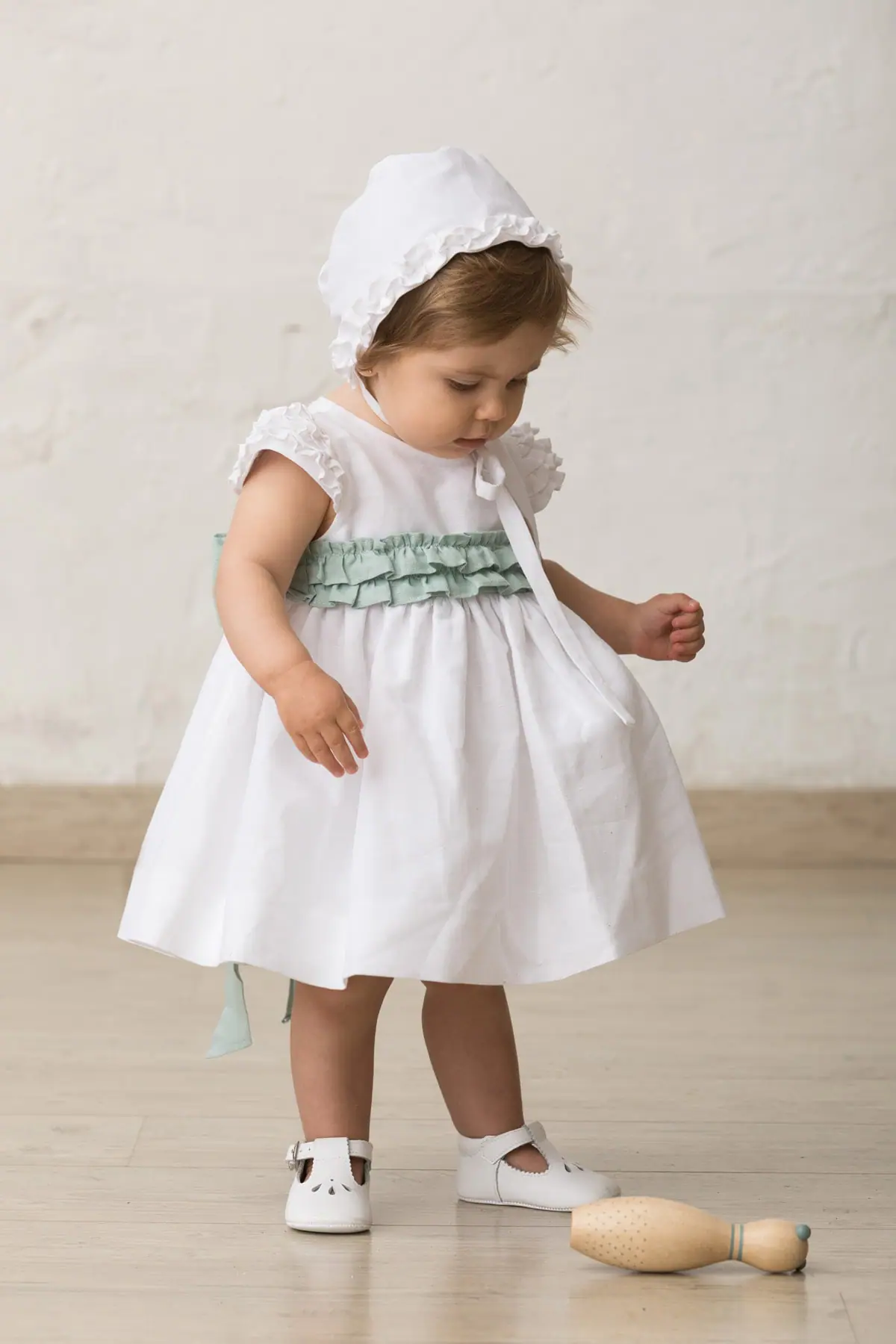 white baby bonnet with ruffle